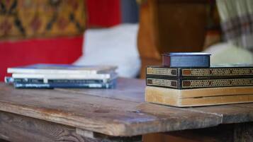 Una mesa de madera con libros y un objeto negro pequeño encima.
