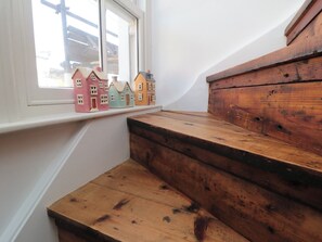 A set of wooden steps leading to a window sill with colorful miniature houses. - Hillsover (Saltburn-by-the-Sea)