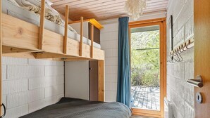 Une chambre avec un lit superposé, une porte coulissante, une vue sur la verdure et un plafond en bois.