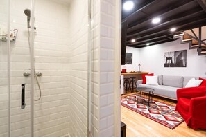 Ein modernes Interieur mit Dusche, einer Couch, einem Couchtisch und einer Treppe.