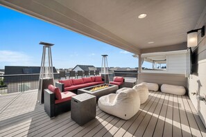 Une terrasse sur le toit avec des sièges extérieurs, un foyer et une vue sur le panorama urbain.