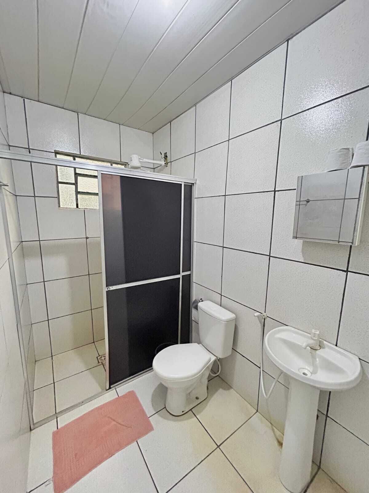 A bathroom with a shower, toilet, and sink.