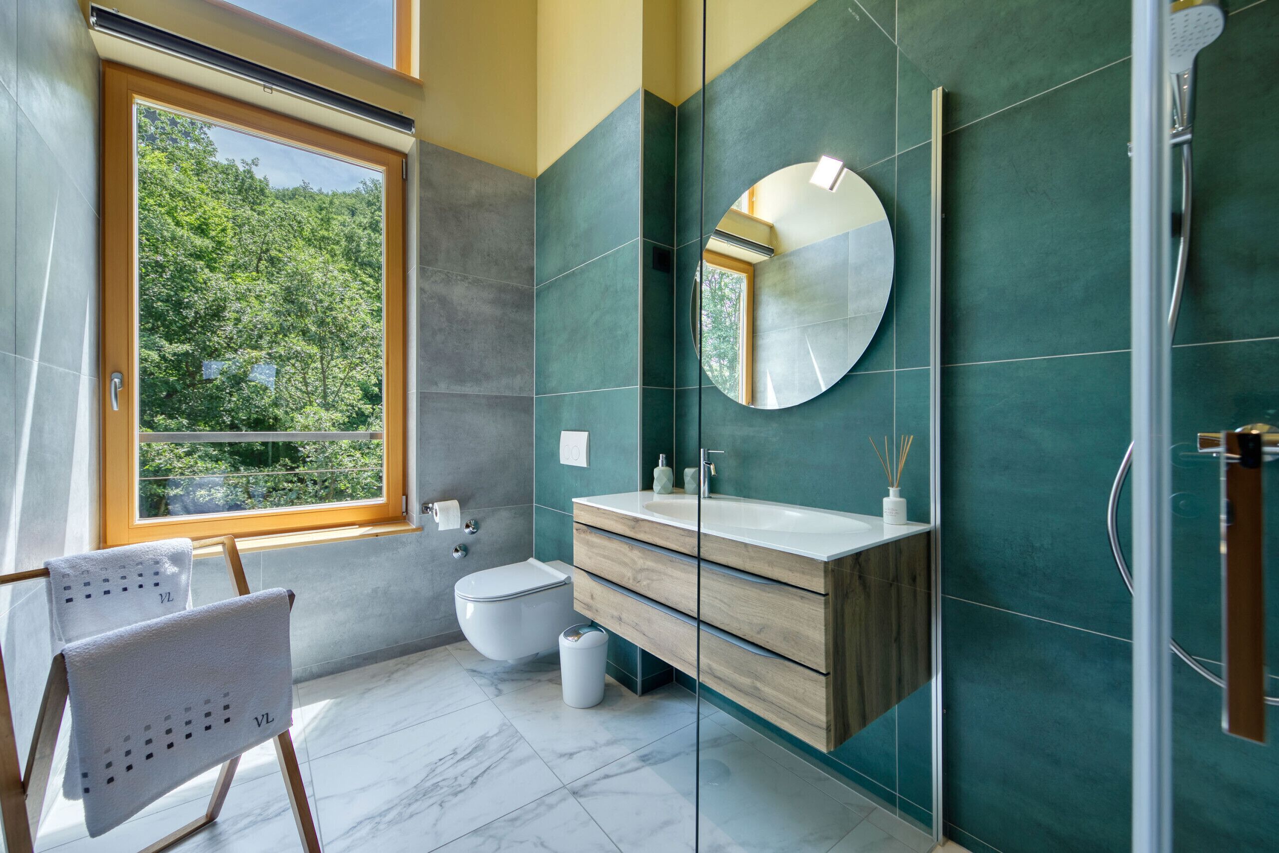 Ein modernes Badezimmer mit Toilette, Waschbecken und Dusche.
