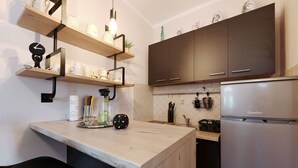 A kitchen with wooden shelves, a refrigerator, and a countertop. - Apartment Laura 1 by the Sea (Maslenica)