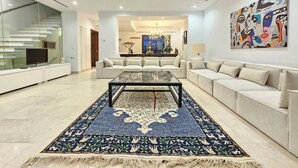 A spacious living room with a large coffee table, a patterned rug, and a modern chandelier. - Luxurious 7-bedroom Villa in La Marsa, Tunisia - Modern Comfort & Elegance (La Marsa)