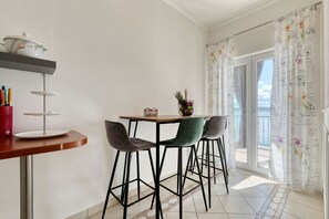 A dining area with a table, chairs, and a view of the sea through a balcony. - Apartment Laura 2 by the Sea (Maslenica)