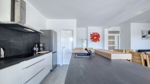 Eine moderne Küche mit schwarzer Arbeitsplatte, weißen Schränken und einer großen roten Blütenblumen-Dekoration.