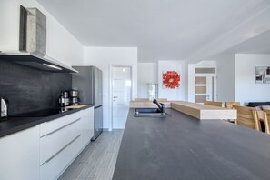 Eine moderne Küche mit schwarzer Arbeitsplatte, weißen Schränken und einer großen roten Blütenblumen-Dekoration.
