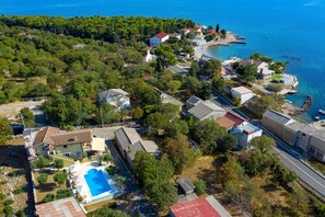 An aerial view of a coastal residential area with houses, a swimming pool, and a marina. - Villa Paulina with Heated Pool (Starigrad)