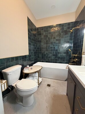 Un baño con inodoro, lavabo, bañera y ducha.