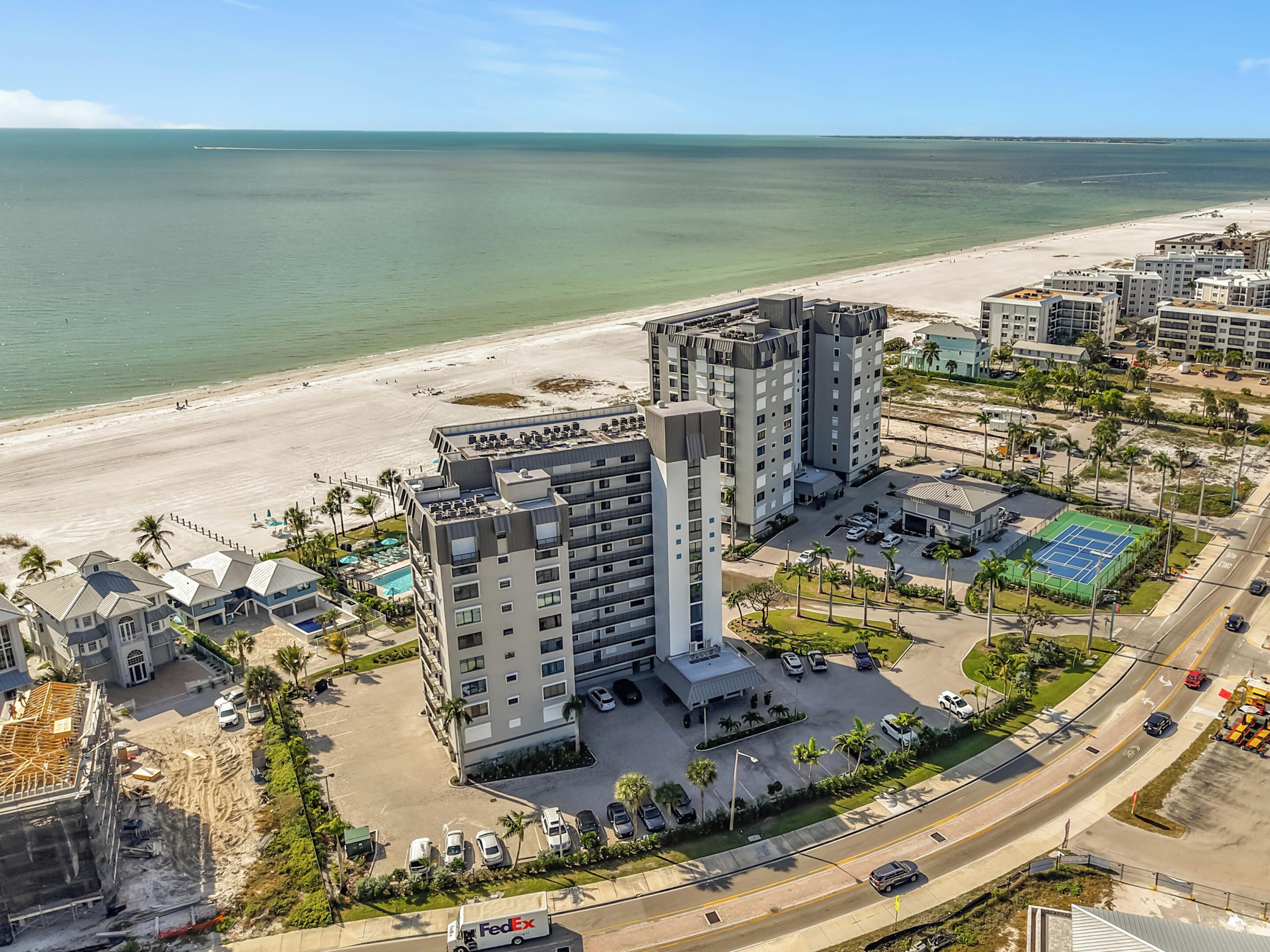 Un hôtel de grande hauteur, avec de nombreux étages, un parking et une vue sur la plage.