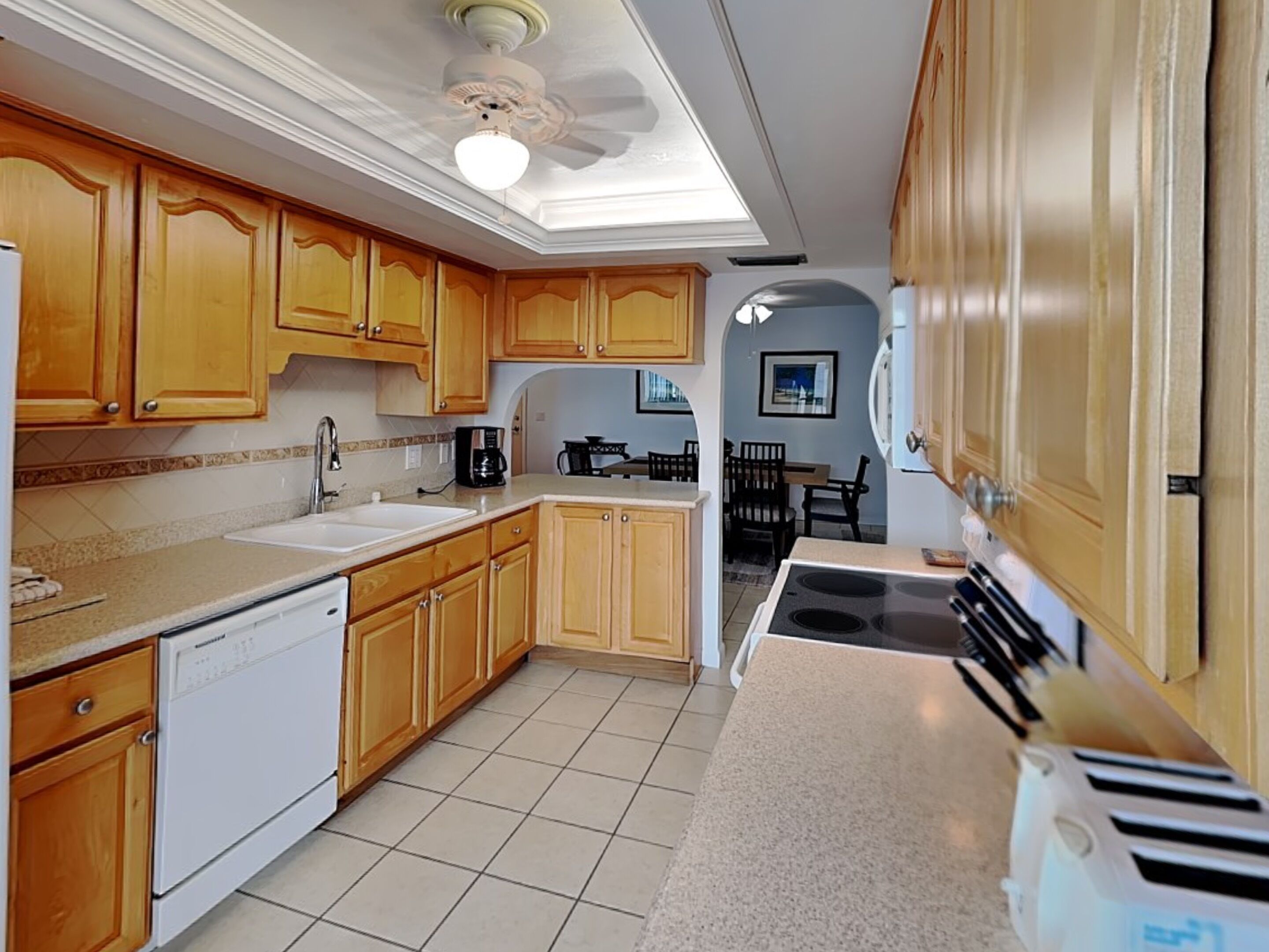 A kitchen with wooden cabinets, a dishwasher, a stove, and a toaster.