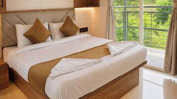 A large bed with a wooden headboard, white bedding, and two brown pillows.