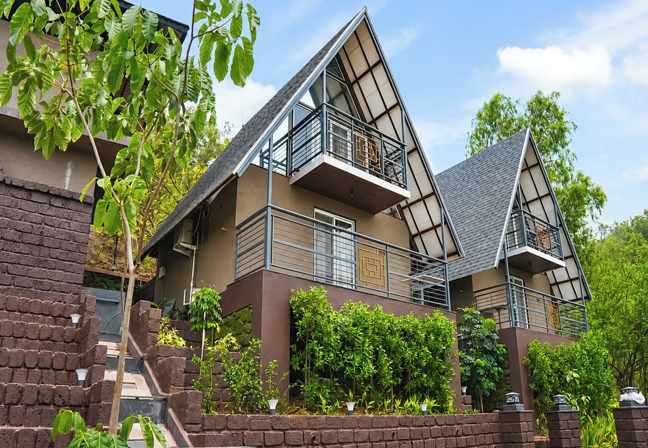 Een modern meerlaags huis met balkon, bakstenen muren en beplanting.
