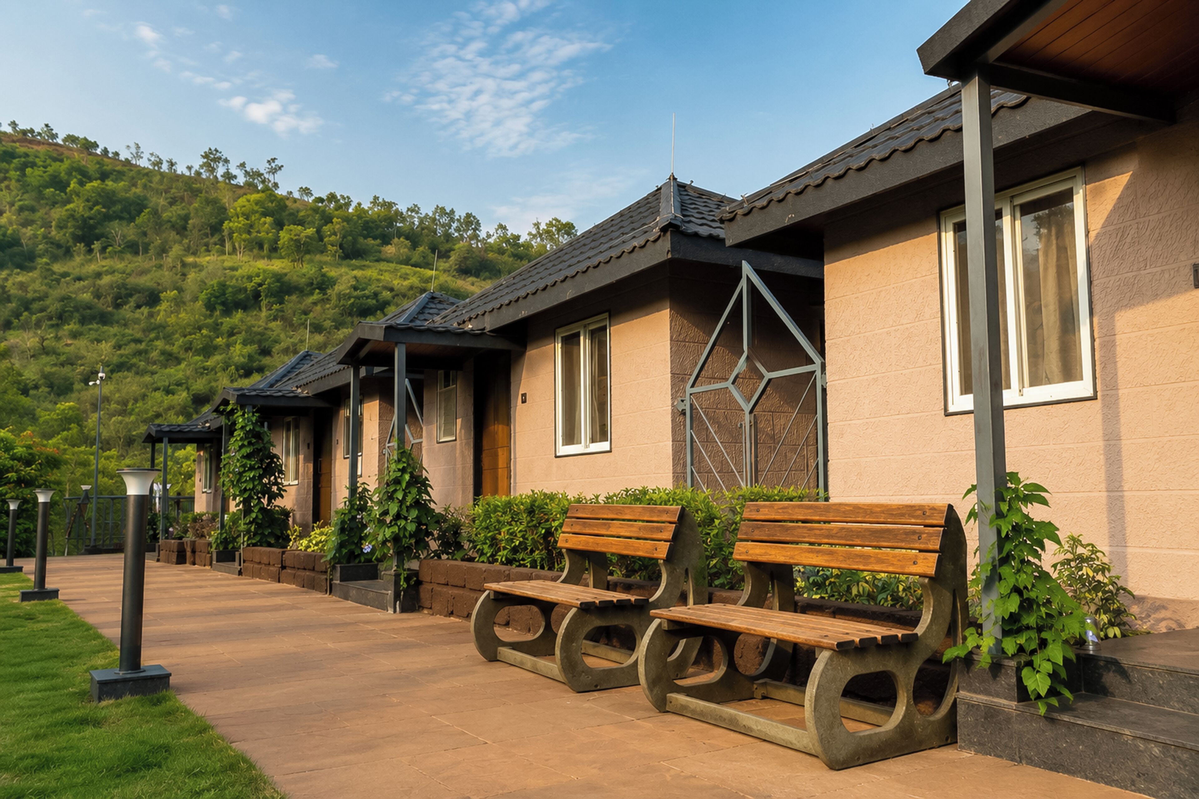 A building with a sloped roof, a paved walkway, and benches.