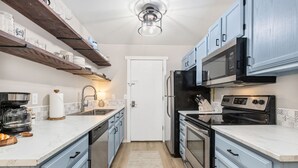 A compact kitchen with a white countertop, stainless steel appliances, and light blue cabinetry. - Windsor Wanderer | Walk to Parks, Pool, Downtown (Windsor)