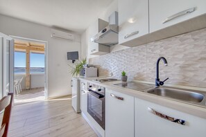 Eine moderne Küche mit großem Fenster, eingebautem Backofen und Spüle.