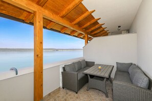 Ein überdachter Sitzbereich mit Blick auf das Wasser.