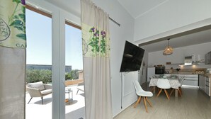 Un appartement moderne doté d’un balcon, d’un coin repas et d’une cuisine.