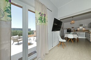 Eine moderne Wohnung mit Balkon, Essbereich und Küche.