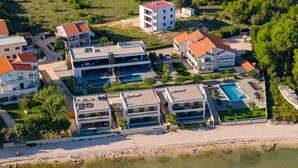 A coastal hotel with multiple buildings, a swimming pool, and a beach area. - Apartment Suva Punta 1 by the Sea (Vir)