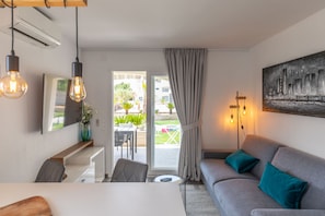 A modern living room with a sofa, a dining table, and a TV. - Apartment Suva Punta 2 by the Sea (Vir)