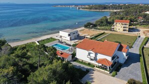 A coastal property with a swimming pool, a large building with a red roof, and a view of the sea. - Apartment Suva Punta 2 by the Sea (Vir)