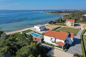 A coastal property with a swimming pool, a large building with a red roof, and a view of the sea. - Apartment Suva Punta 2 by the Sea (Vir)