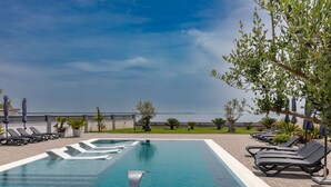 A swimming pool with lounge chairs and a view of the sea. - Apartment Suva Punta 2 by the Sea (Vir)