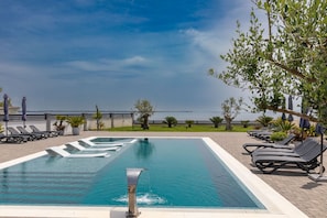 A swimming pool with lounge chairs and a view of the sea. - Apartment Suva Punta 2 by the Sea (Vir)