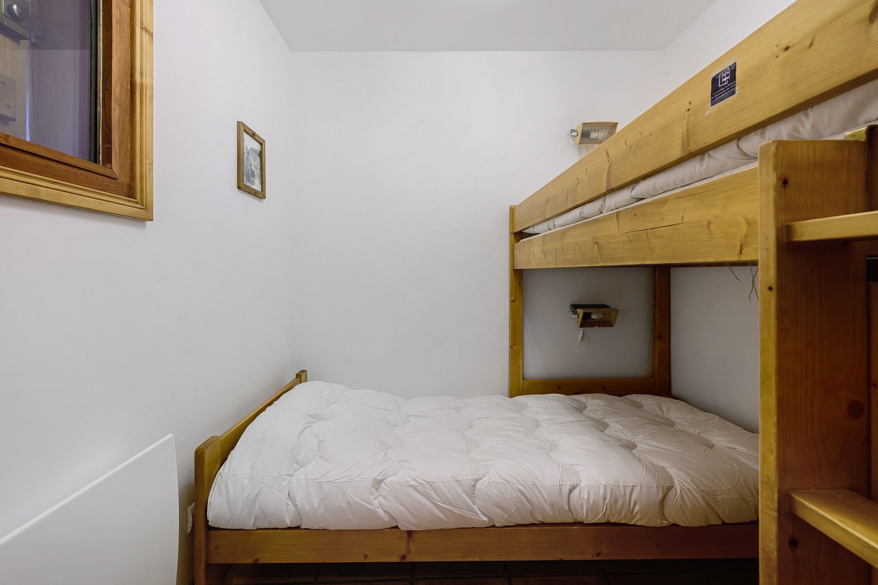 Une chambre avec un lit superposé, comprenant un lit simple en bas et un autre lit superposé en haut.