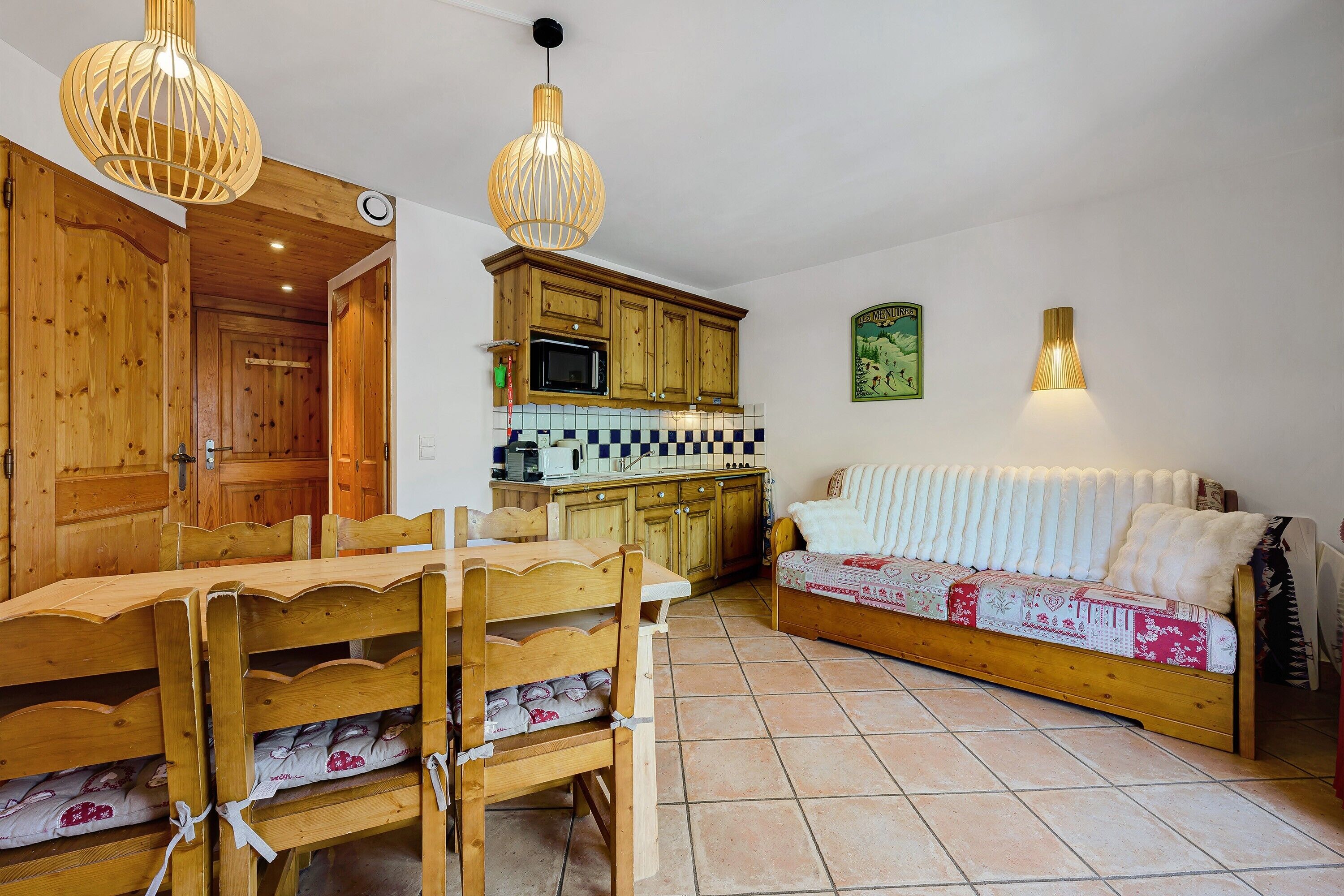 Une cuisine chaleureuse avec des meubles de rangement en bois, une table à manger et un canapé.