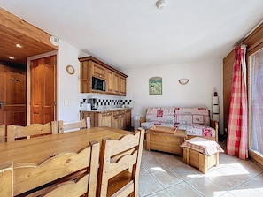 A compact living space with a kitchen, dining area, and seating area. - Apartment "Les Ancolies" with Balcony (Les Belleville)
