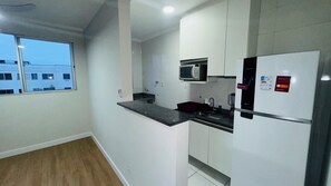 Eine moderne Küche mit Mikrowelle, Kühlschrank und Spüle.