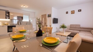 Una cocina moderna con comedor, un sofá y un televisor de pantalla plana.