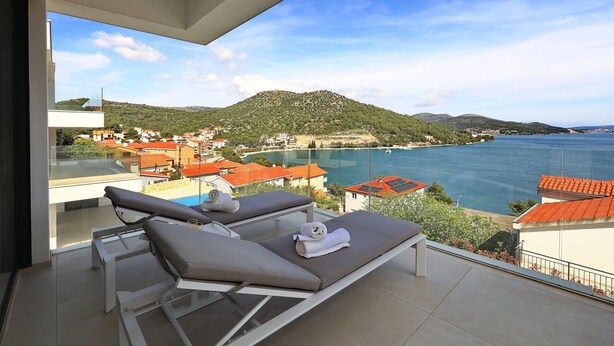 A balcony with two sun loungers and a view of a coastal town. - Apartment Mentis with Sea View (Marina)