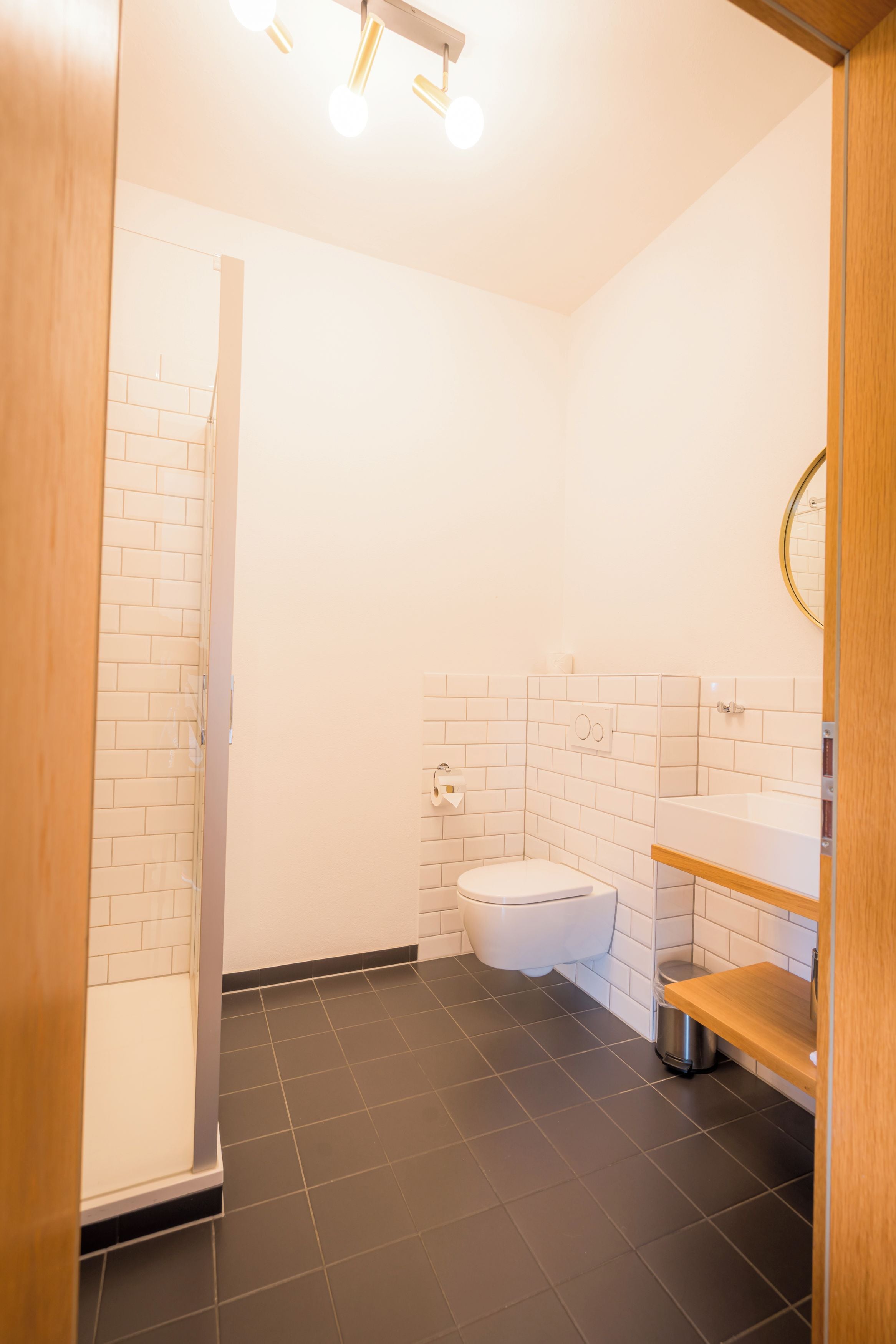 A modern bathroom with a shower, toilet, and sink.