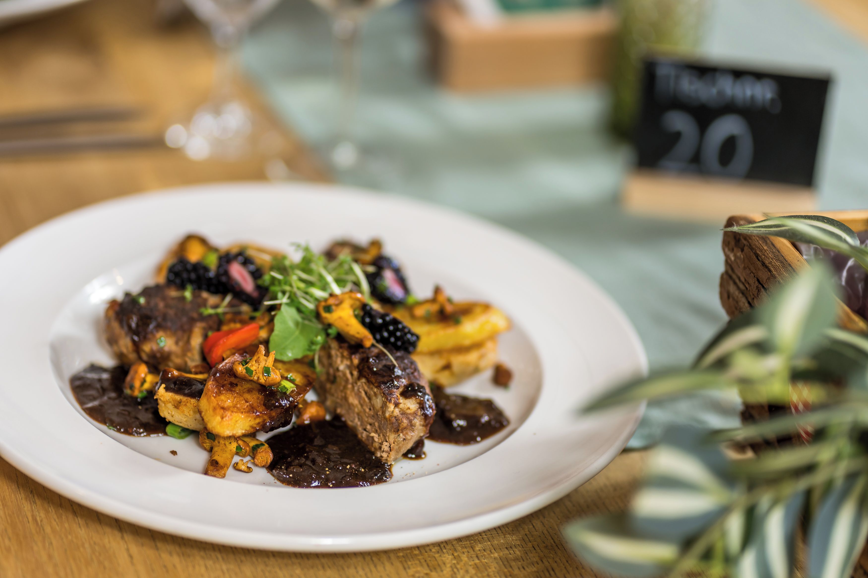 Ein Teller mit Speisen, darunter verschiedene Gemüsesorten und ein Fleischgericht, vermutlich ein Steak, auf einem weißen Teller.