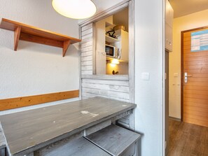 A kitchen with a wooden countertop, a hanging light fixture, and a door with a calendar. - Studio Tignes, walk-to-ski, mountain views (Tignes)