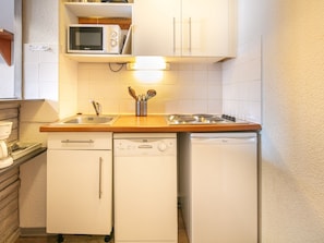 A compact kitchen with a microwave, stove, sink, and dishwasher. - Studio Tignes, walk-to-ski, mountain views (Tignes)