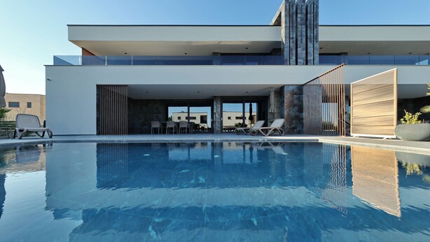 A modern building with a swimming pool, outdoor seating, and a covered patio area. - Villa Suva Punta Elite with Private Pool (Vir)