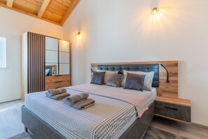 A bedroom with a bed, bedside tables, a mirror, and wall-mounted lights. - Holiday Home Fortica with Sea View (Ražanac)
