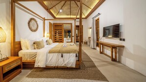 Een slaapkamer met een houten hemelbed, een flatscreen televisie en een grote spiegel.