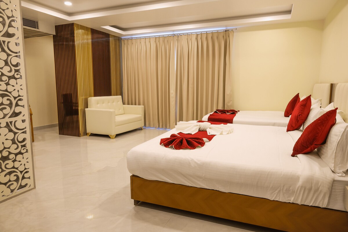 Una habitación de hotel con una cama grande, un sofá independiente, un panel decorativo y una cortina.