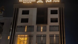 Een meerlaags gebouw met een bord waarop 'BRIDDHISHREE PLACE' staat en een logo.