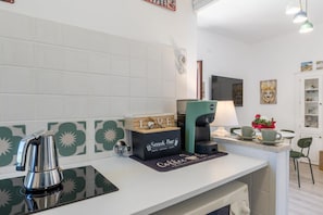 Eine Küchenzeile mit einer Kaffeemaschine, einer Box mit der Aufschrift 'Snack Bar' und einem Kaffee-Pod-Halter.
