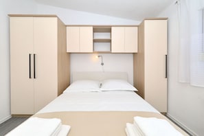 Ein Schlafzimmer mit einem Bett, zwei Schränken und einer Wandleuchte.
