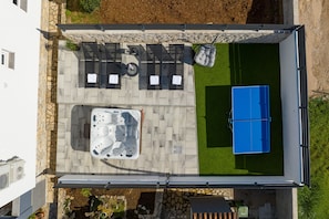 Eine Dachterrasse mit Whirlpool, Sitzgelegenheiten im Freien und einem Swimmingpool.