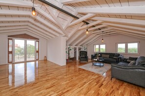 Ein geräumiger Loft mit hohen Decken, großen Fenstern und Holzboden.