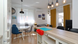 Ett modernt kök med matplats, träskåp och en inbyggd ugn.